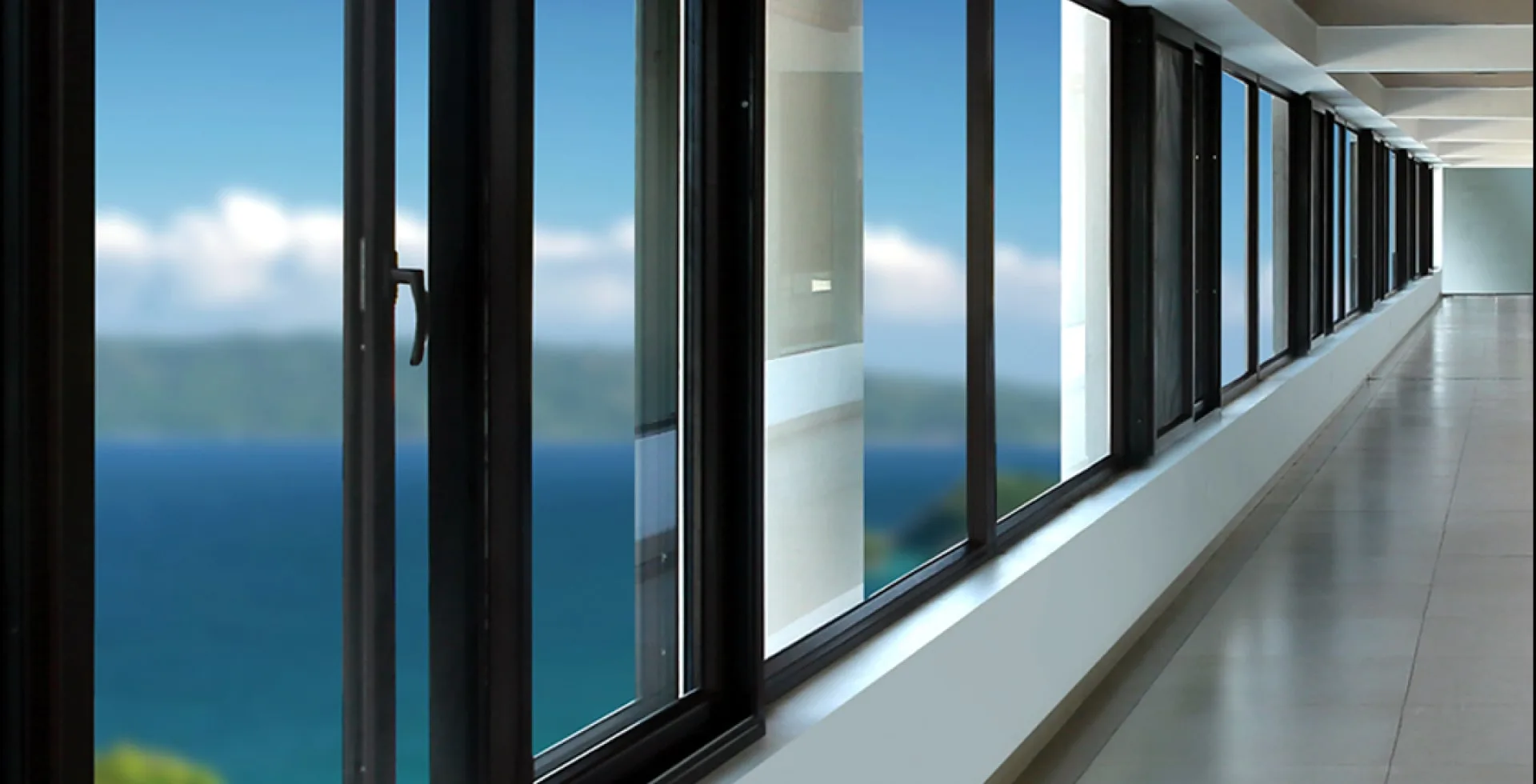 Dark uPVC casement windows running along a glazed corridor with a sea view — Mason uPVC